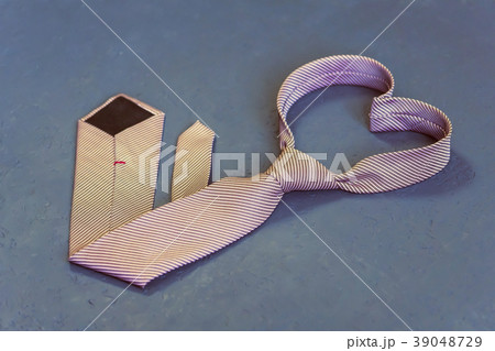 pink tie is tied in the shape of a heart on a gray pink tie is tied in the shape of a heart on a gray 39048729