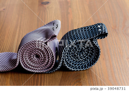 two men's ties, rolled up on a wooden background two men's ties, rolled up on a wooden background 39048731