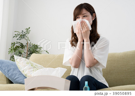 花粉症の女性 ティッシュ 鼻水 鼻炎の写真素材