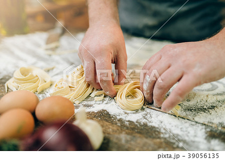 Chef hands preparing pasta, fettuccine preparation Chef hands preparing pasta, fettuccine preparation 39056135