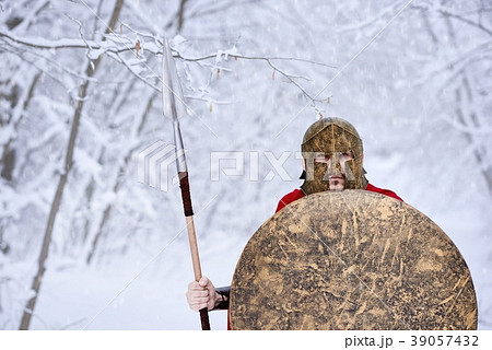 Spartan keeping spear and shield in snowy forest. Spartan keeping spear and shield in snowy forest. 39057432