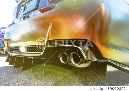 Orange car with dual exhaust pipes on concrete Orange car with dual exhaust pipes on concrete 39060892