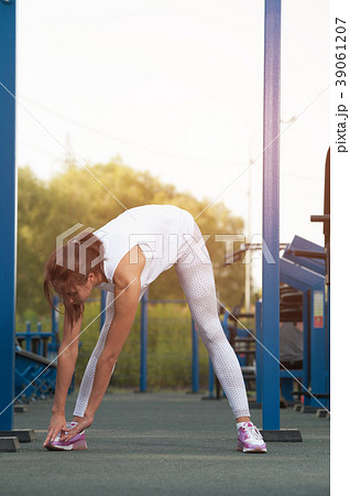 Slim brunette woman exercising in outdoor gym Slim brunette woman exercising in outdoor gym 39061207