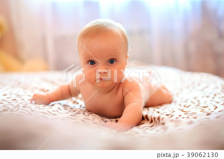 Happy baby girl wearing pampers in white sunny Happy baby girl wearing pampers in white sunny 39062130