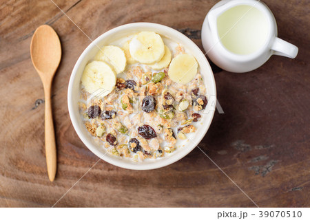 Muesli cereal with slice banana and milk  39070510