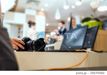 Hand of the camera operator touching a modern DSLR 39076980