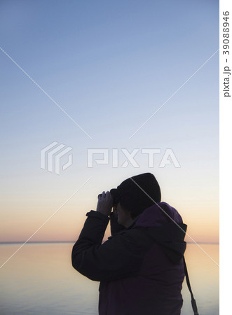 Senior woman birdwatching at sunset 39088946
