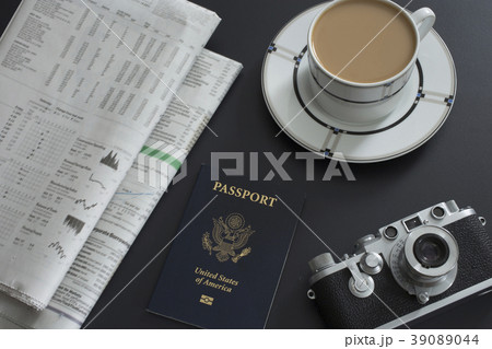 Passport, coffee, old camera and newspapers lying on table Passport, coffee, old camera and newspapers lying on table 39089044
