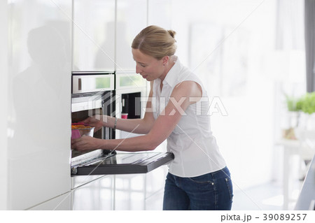 Woman using oven in kitchen 39089257