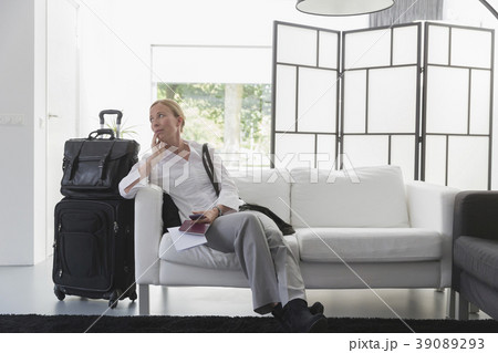 Mature woman waiting with luggage in modern living room 39089293