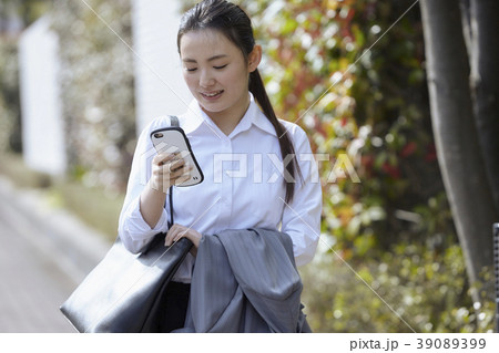 屋外でスマホを使う若いビジネスウーマン 屋外でスマホを使う若いビジネスウーマン 39089399