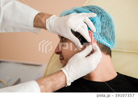 Otolaryngologist hands check patient ear 39107357
