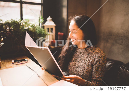 business girl studying the menu in restaurant 39107777