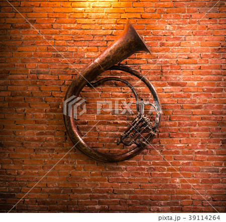 Old French horn on brick wall background. 39114264