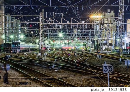 夜にテールライトの尾を引く都会の電車車庫の写真素材