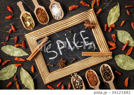 Various spices in wooden spoons  on dark  table.  39125882
