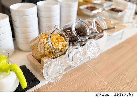 Glass jar filed by oatmeals, cornflakes and raisin 39135665