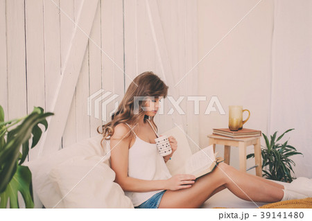 Young woman at home sitting on bed and relaxing 39141480