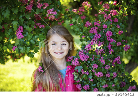 Pretty smiling girl in pink blossom garden 39145412