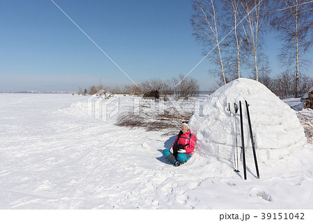 Happy woman skier sitting near an igloo Happy woman skier sitting near an igloo 39151042