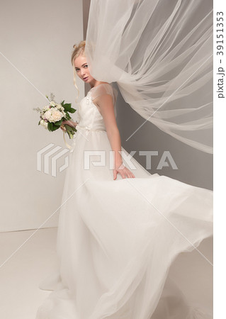 Bride in beautiful dress standing indoors in white Bride in beautiful dress standing indoors in white 39151353
