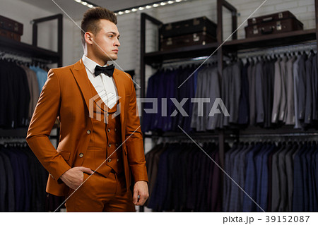 young man in classic vest against row of suits in 39152087
