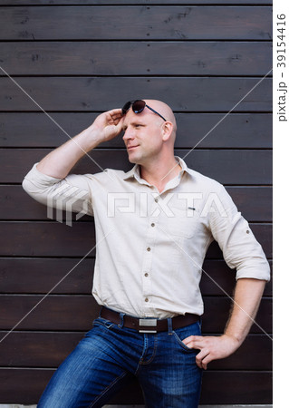 handsome Bald man stand on the wooden brown backgr 39154416