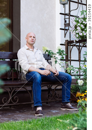 Bald man sit on the bench at garden at spring time 39154419