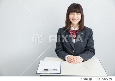 塾の椅子に座る制服姿の女の子の写真素材