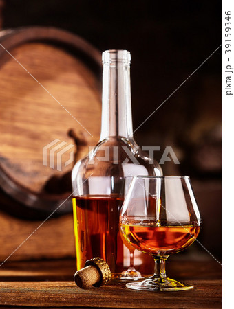 Glass and bottle of Cognac on wodden table 39159346