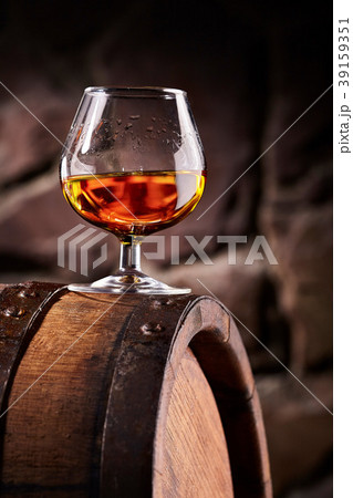 Glass of cognac on the old wooden barrel Glass of cognac on the old wooden barrel 39159351