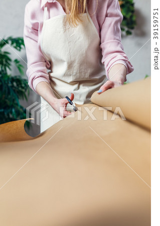 Female florist cutting wrapping paper with 39159751