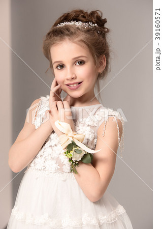 Little pretty girl with flowers dressed in wedding 39160571