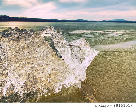 Heap of shining ice on beach. Ice in overlaid bay Heap of shining ice on beach. Ice in overlaid bay 39161017