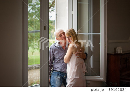 Senior Man Hugging His Young Blond Wife near the 39162024