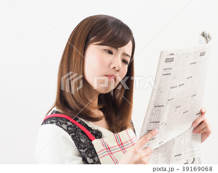 経済新聞を見て悩む女性 39169068