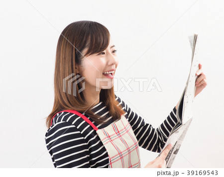 経済新聞を見て微笑む女性 39169543
