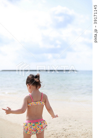 海 ビーチ 子供 女児 夏休み リゾート バカンス 家族旅行 後姿 顔なし 南国 コピースペース の写真素材