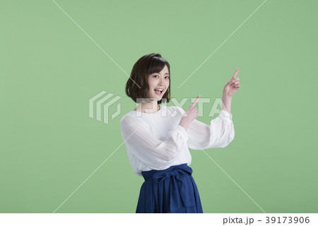 若い女性　指差し　緑バック 39173906