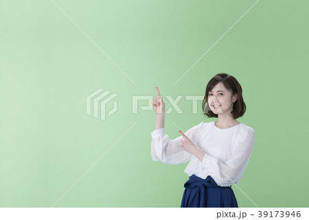 若い女性 指差し 緑背景 若い女性 指差し 緑背景 39173946