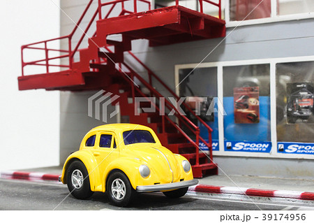 Yellow toy car parking in front of custom car shop 39174956