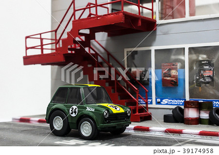 Green toy car in front of custom car shop 39174958