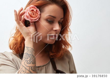 A beautiful girl with red hair decorates her hair A beautiful girl with red hair decorates her hair 39176850