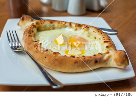 Adjarian khachapuri with eggs on the table Adjarian khachapuri with eggs on the table 39177186