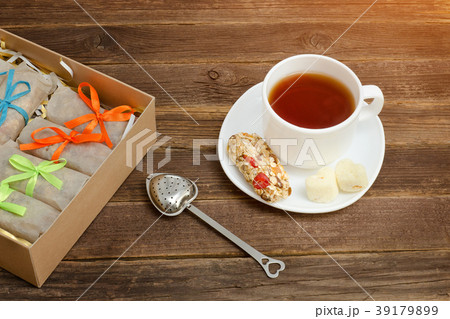 Mug of black tea, a bar of muesli and boxes 39179899