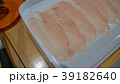 Chicken slices in white dish on wood table. 39182640