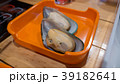 Mussel in plastic plate on wood table. 39182641