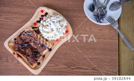 Toast bread with ovaltine and cream in wood dish. 39182644