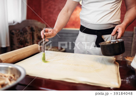 Male chef cooking apple strudel on the kitchen Male chef cooking apple strudel on the kitchen 39184048