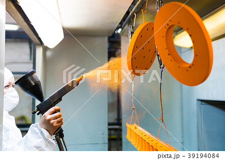 Powder coating of metal parts. A woman in a Powder coating of metal parts. A woman in a 39194084